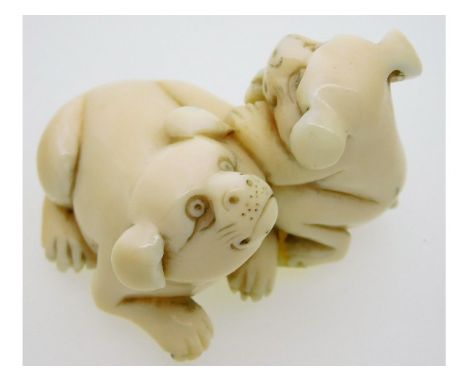 An early 20thC. Japanese netsuke of two puppies 