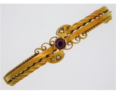 An Edwardian 15ct gold bangle set with two small diamonds &amp; approx. 0.65ct ruby, internal diameter 54mm, with original bo