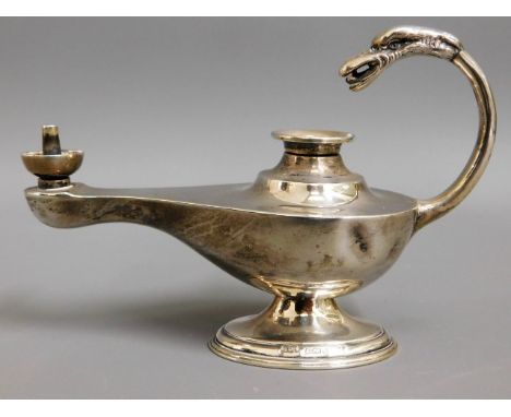 A 1901 Birmingham silver oil lamp with phoenix head on handle by Synyer &amp; Beddoes, lacking snuffer, two light bumps, 5in 