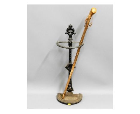 A Victorian cast iron stick stand &amp; walking cane, stick stand has crack to one part of D, stamped No.54 to rear, 29in hig