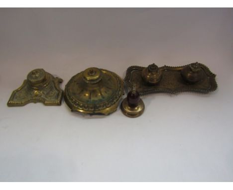 Three late Victorian brass inkwells and a brass and polished stone paperweight (4)