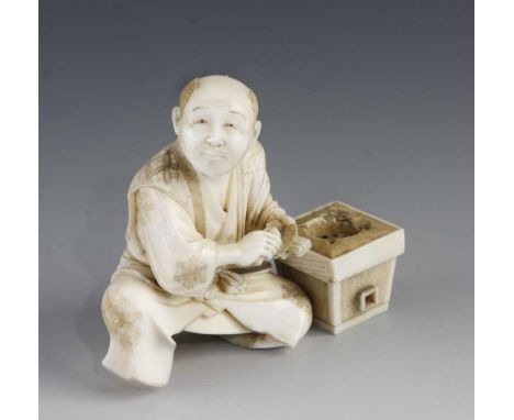 A 3" ivory okimono of a man with trowel at work