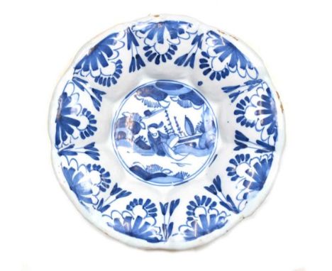 Late 17th Century English Delftware buckle plate, circa 1680, decorated in underglaze blue with a primitive scene of a figure