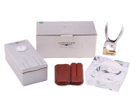 A David Linley crystal glass cigar ashtray, together with Chrysler branded humidor, a cigar case and a cigar cutter.