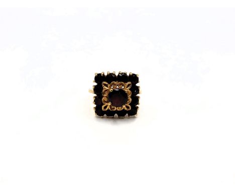 A yellow gold (stamped) 18K multiple garnet set square shaped cocktail ring. 7.3gms Size K.