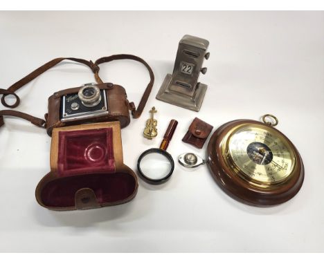Magnifier glass 11cm, compass 5cm, mini brass violin 7cm, a vintage camera in leather case, a small barometer, and a desk cal