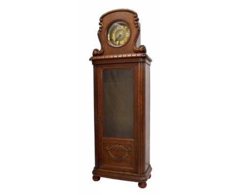 Unusual oak eight day longcase clock, the 9" round brass dial within a foliate carved surround over a long glazed door, 69.5"