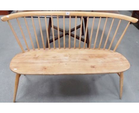 Good blonde Ercol two seat bench with comb back, the oblong seat upon splayed legs, width 44.25' (a.f)