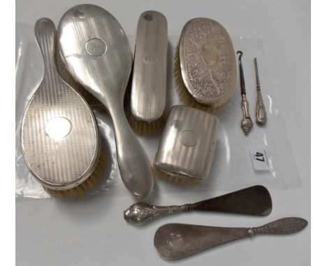 Silver dressing table items including five clothes brushes, button hook, nail file and two shoe horns