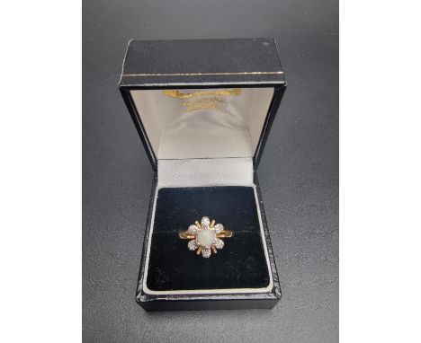 A yellow metal ring, set central cabochon opal surrounded by six diamonds, stamped '18ct', size M 1/2. 