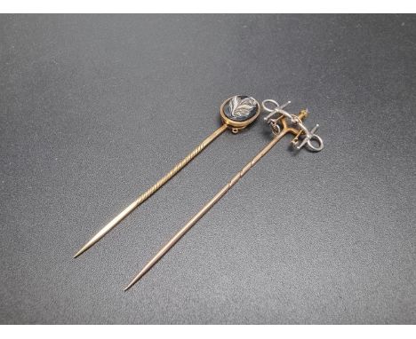 A 19th century yellow metal and carved agate stick pin,&nbsp;the reverse inset hair and inscribed 'Llewelyn Traherne Esq', 73