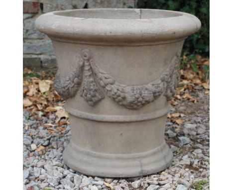 A DARK STONEWARE CIRCULAR PLANTER decorated with floral swags 53cm wide 
