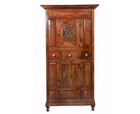 AN ANTIQUE INDIAN HARDWOOD PANTRY CUPBOARD, with stepped pediment over a single florally carved panelled door, flanked to eit