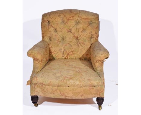 AN EARLY 20TH CENTURY BUTTON BACKED LIBRARY ARMCHAIR with roll over arms and ring turned front legs terminating in brass cast