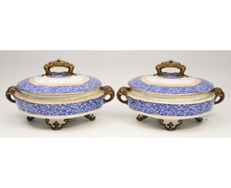 A PAIR OF WORCESTER PORCELAIN TUREENS decorated with blue and white flowers with gilt highlights and stylised elephant handle
