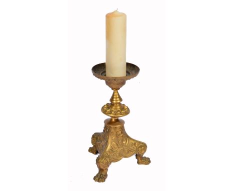 A GILT METAL PRICKET CANDLESTICK, cast with stylized berries and foliage on a triform base with three paw feet, 36cm high