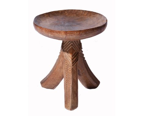 A CAMEROONIAN CARVED WOODEN DISHED TOPPED STOOL on tripod base, 30cm in diameter 