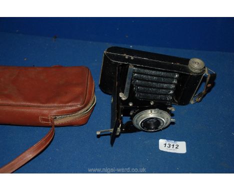 A cased Kodak six -20 folding 'Brownie' made in Britain Camera with 100 mm Anaston lens and Dakon shutter.