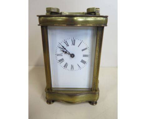 A carriage clock with serpentine sides, Roman numeral dial, approx 12cm high, with key, currently running in the saleroom, da