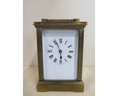 A carriage clock with roman numeral dial, approx 13cm high overall, with replacement mirrored panels, signs of wear throughou