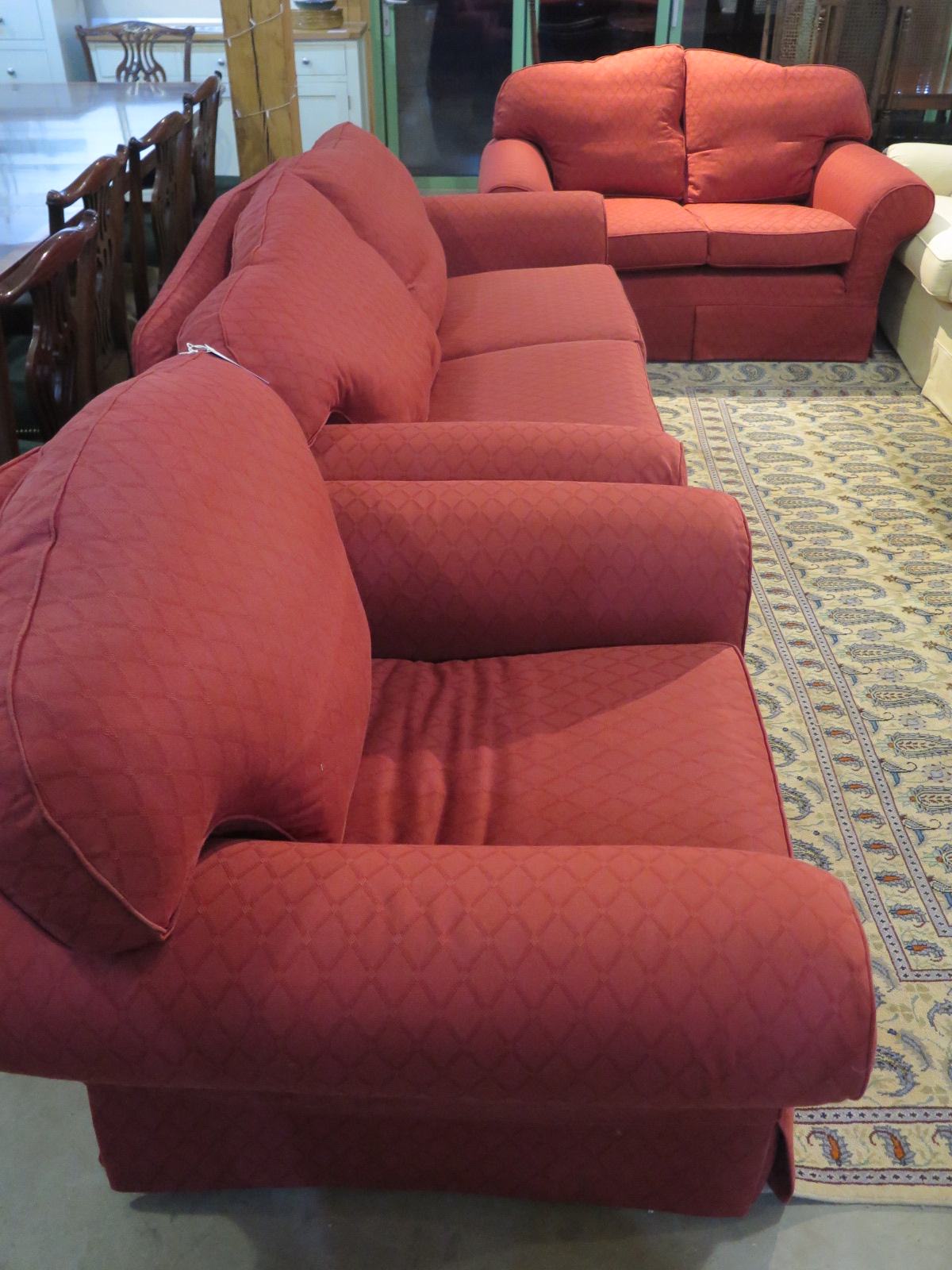 A Multiyork three piece suite in red material, large two seater sofa