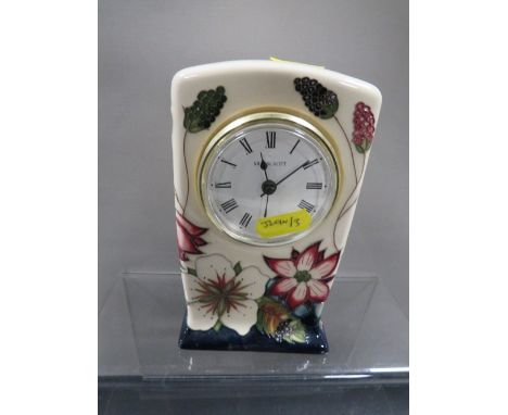 A Moorcroft tube line decorated mantle clock, with flowers and raspberries