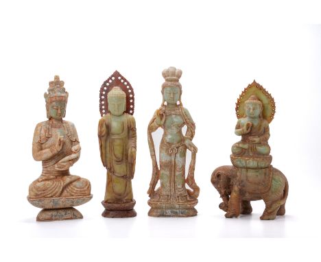 FOUR ORIENTAL CARVED HARDSTONE/JADE FIGURES Of Buddhist forms, one seated on a lotus plinth, another seated on an elephant, a