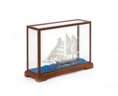 A SILVER FILIGREE MODEL OF A SHIP
In a glazed wooden case
Marked '925' to the hull
20cm high x 28.5cm x 10cm
Condition: For a