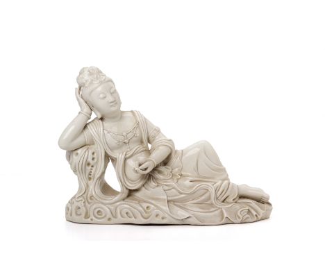 A BLANC DE CHINE MODEL OF A RECUMBENT GUANYIN
Modelled reclining and holding a pearl
Impressed seal mark to the reverse
23cm 