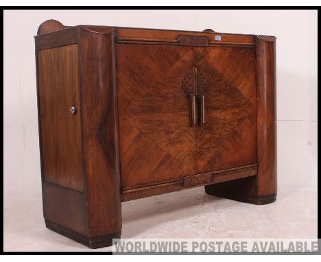 A 1930's Art Deco walnut sideboard. Of angular form with bow fronted ends having central cupboards with appointed interior. M