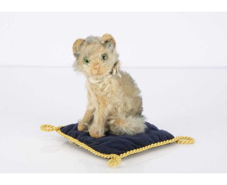 A Steiff seated Fluffy cat late 1920s, with grey tipped cream mohair, green and black glass feline eyes, pink stitched nose a