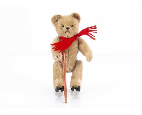 A post-war Schuco clockwork skating Rally Teddy Bear, with beige mohair, brown and black glass eyes, black stitched nose, mou