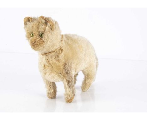 An early Steiff standing cat circa 1908, with white mohair, green and black glass feline eyes, pink stitched nose and mouth, 