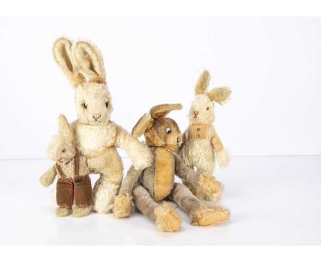 Four soft toy rabbits, an unjointed rabbit with integral dungarees, black boot button eyes, pink and brown stitched nose and 