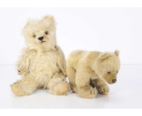A post war Steiff standing bear cub, with beige mohair, glass eyes and felt pads —8in. (20cm.) long; and a teddy bear with lo