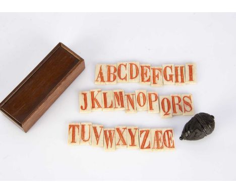An unusual set of bone alphabet dominos, the letter stained red with dominos on the reverse, in original wooden box with slid