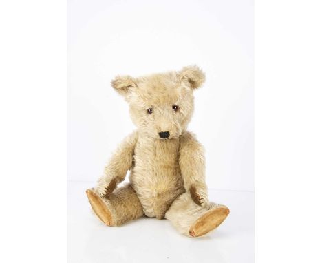 A post-war Chiltern Hugmee Teddy Bear, with blonde mohair, orange and black glass eyes, muzzle with black stitched nose, mout
