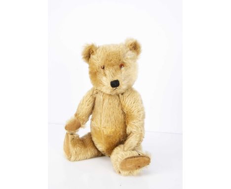 A post-war Chiltern Hugmee Teddy Bear, with blonde mohair, orange and black plastic eyes, muzzle with black stitched nose, mo