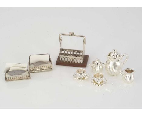 Simply Silver by Vic Pain dolls’ house silver chattels, comprising a Tantalus 1 1/4in. (3cm.) high and two letter racks; and 