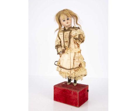 A late 19th century tea drinking automaton, with bisque headed marked 1902, fixed blue glass eyes, blonde hair wig, bisque ar