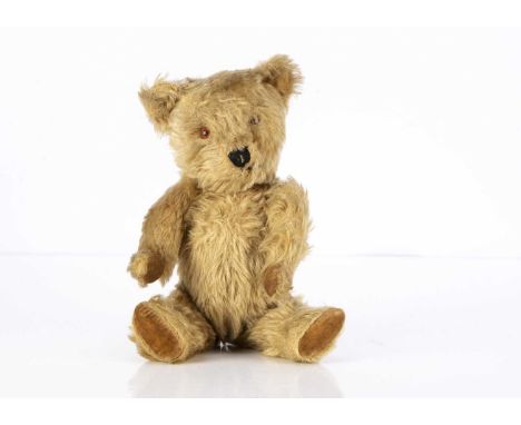 A post-war Chiltern Teddy Bear, with dark blonde mohair, orange and black plastic eyes, black stitched nose and mouth, swivel