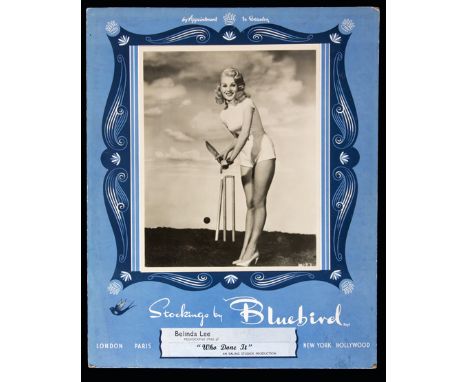 A self-standing shop counter advertisement card for Bluebird Stockings featuring a glamorous film studio photograph of the ac