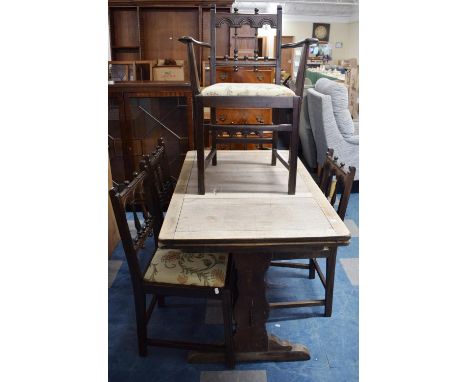 A Vintage Refectory Style Stained Oak Drawer Leaf Dining Table and Six Spindle Back Dining Chairs with Tapestry Pad Seats 