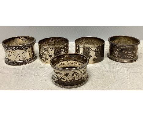 Four silver hallmarked napkin rings plus one white metal (marks rubbed) total weight of 4, 119.5gms unmarked 12.7gms.