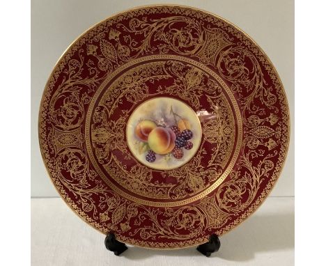 A Royal Worcester fruit decorated cabinet plate by P. Stanley decorated with peaches and brambles, red ground detailed with f