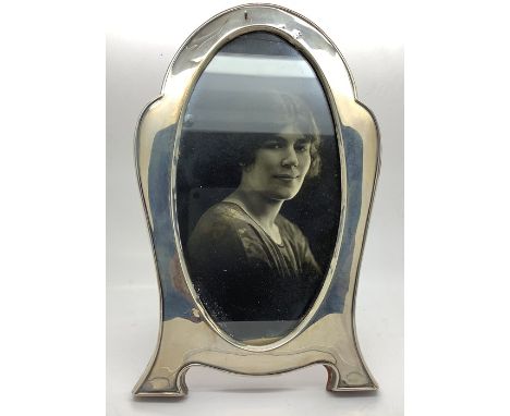 A silver photograph frame, Birmingham 1922, slight dint to top with oak back and stand. 19.5cms h. 