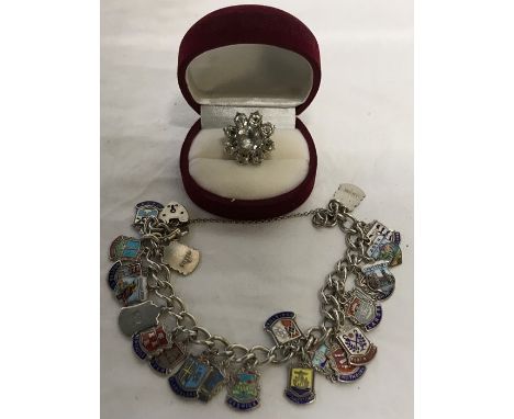 Silver charm bracelet with enamel charms marked silver together with flower brooch set in white metal. Bracelet 48.7gms total