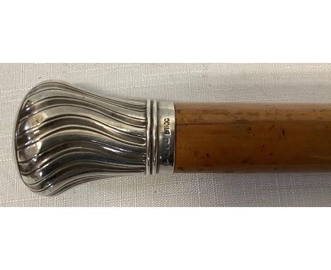 A silver topped cane, 89cms, 1 mark rubbed, London late 19thC crest to top.