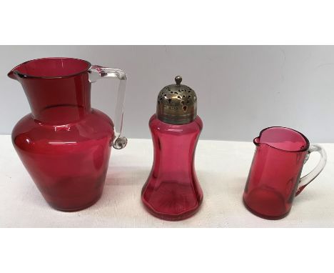 Three pieces of 19thC cranberry glass including a silver topped sugar shaker, Birmingham 1905 and two jugs. 14cms h, all in g