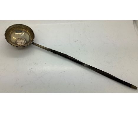 A  silver and baleen toddy ladle a/f with a Queen Anne 1707 shilling to centre. 41.5gms. 